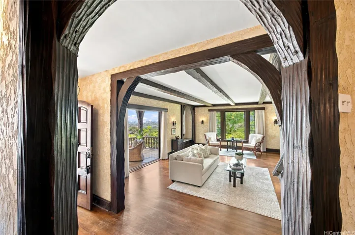 Classic arches and timber beams frame the beautiful entry hall leading to the dramatic living room.