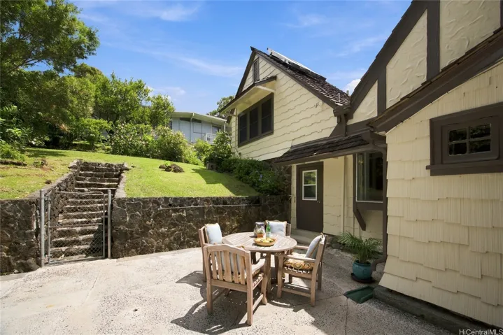Rear patio offers plenty more entertaining or play space. Steps lead to back yard and cottage.