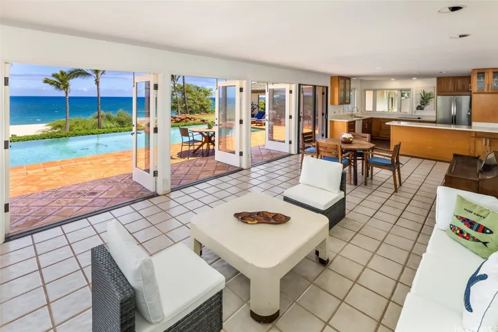 Large open space floor plan connects living, dining, & kitchen, dining, living room to pool, sandy beach, and ocean.
