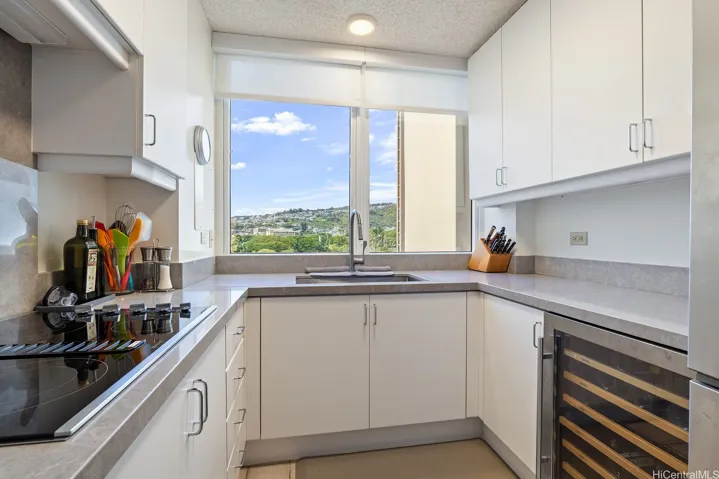 Efficient galley kitchen equipped with under-counter wine frig, cook top, built-in microwave and oven.