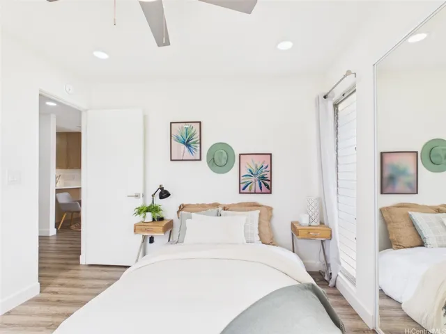 Primary bedroom with mirrored closet, ceiling fan, and its own AC