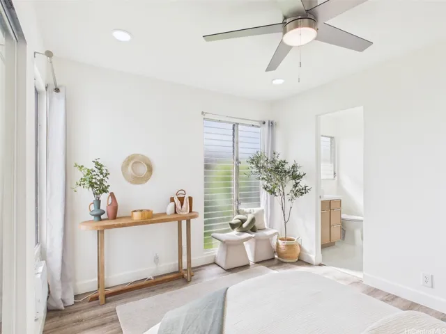 Primary bedroom corner with the renovated bath beyond