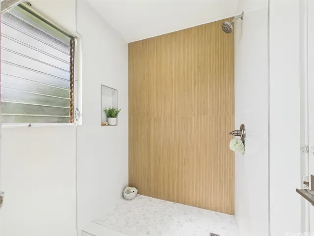 Walk-in shower with wood-look slat tile and pebble-stone floor