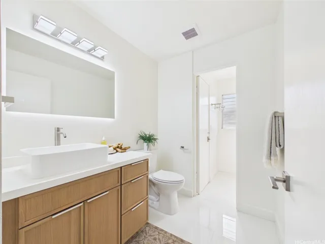 Quartz-top vanity with vessel sink and lighted mirror