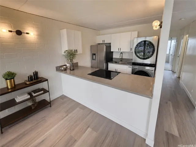 A newly remodeled kitchen with fresh cabinets, quartz countertops, new appliances and fresh lighting.