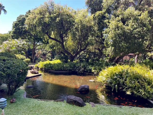 Peaceful walking paths wind through the lush grounds, leading to a serene koi pond and creating a tranquil setting to enjoy the beautiful surroundings.