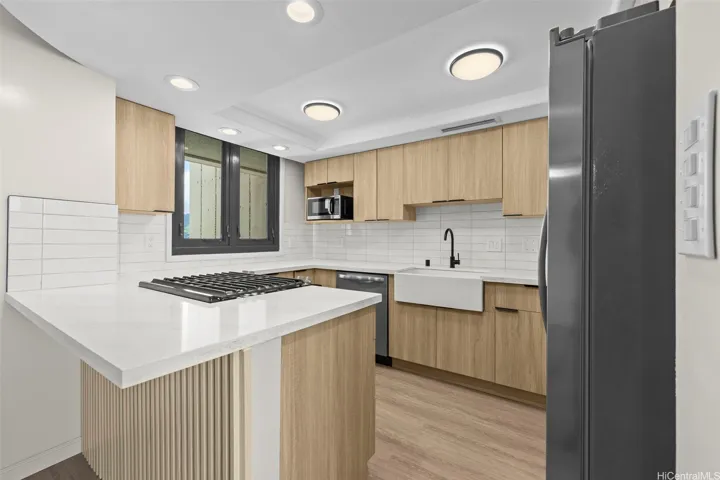Range nicely placed in countertop with bar like space for extra sitting.