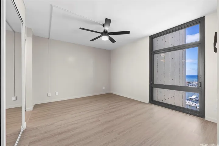 This spacious and inviting primary bedroom is bathed in natural light, that frames a panoramic view of the sparkling blue ocean, creating a serene and tranquil atmosphere perfect for relaxation.