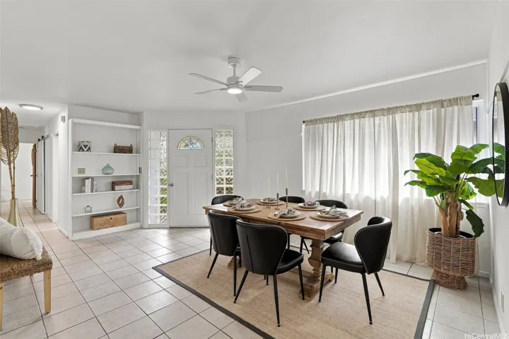 Inviting front entryway transitioning into a spacious and open dining area featuring ceramic tiled flooring flooring and abundant natural light throughout.