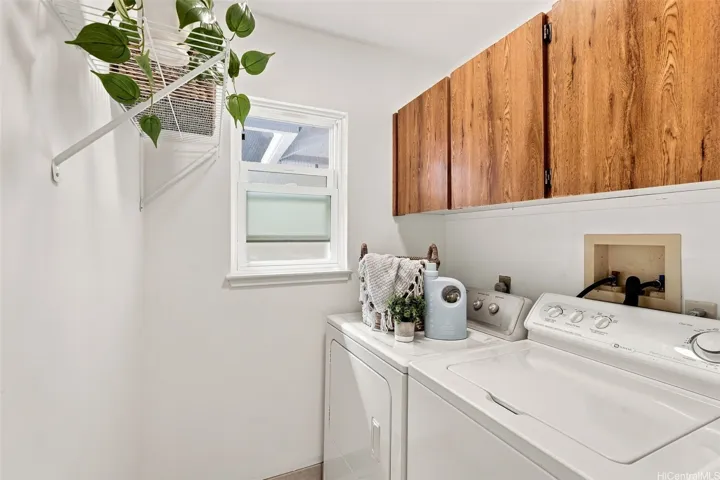 This laundry room is a functional space, featuring a dedicated area for organization, custom cabinetry for ample storage, and plenty of room to keep your household chores streamlined and efficient.
