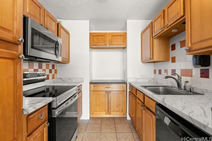 U-shaped kitchen with new countertops, newer microwave and stove. Cabinets have been refinished.
