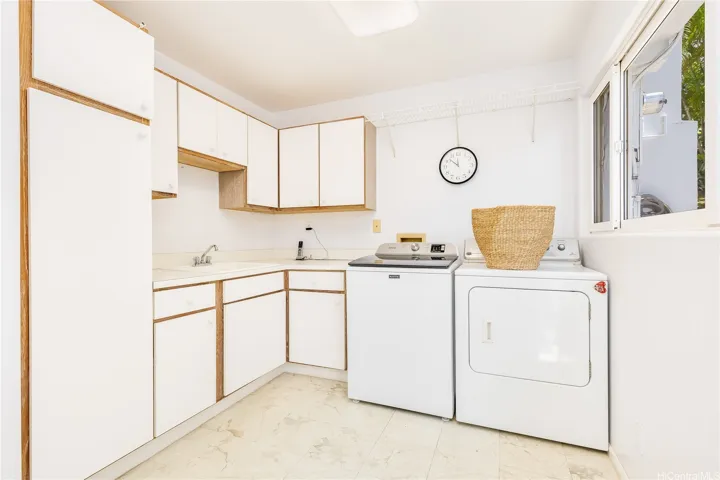 Dedicated laundry complete with laundry sink and plenty of cabinet storage.