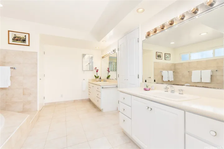 Luxurious primary ensuite with dual vanities, a deep soaking tub, spacious walk-in shower, and private water closet.