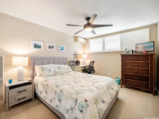 This bright and well-appointed bedroom offers a comfortable and relaxing retreat with plush carpeting, plantation shutters, and soothing neutral tones throughout. A ceiling fan and split-system air conditioning provide year-round comfort, while the spacious layout easily accommodates both sleeping and work-from-home needs, with room for a desk and additional furnishings. Soft natural light filters through the shutters, creating a peaceful ambiance, and ample storage space ensures everyday convenience. Thoughtfully designed and meticulously maintained, this bedroom is ideal as a guest room, family bedroom, or private home office combination.