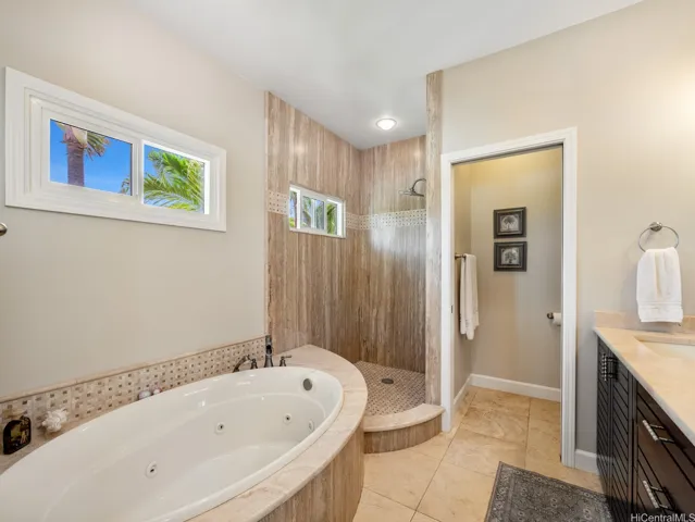 Designed as a luxurious private retreat, the upstairs primary ensuite bathroom offers spa-inspired comfort and elegant finishes throughout. The centerpiece is a relaxing soaking tub, perfect for unwinding after a long day, complemented by a spacious walk-in shower with beautiful floor-to-ceiling tile and decorative accents. A large vanity provides abundant counter space, storage, and functionality for everyday living.