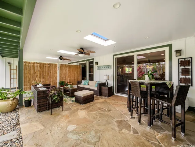 Designed for comfortable indoor-outdoor living, this spacious covered lanai serves as a true extension of the home. Featuring elegant natural stone flooring, skylights that fill the space with natural light, and ceiling fans for added comfort, this inviting retreat is perfect for relaxing or entertaining year-round.