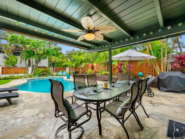 Enjoy resort-style outdoor living in this inviting poolside retreat. The spacious covered lanai creates the perfect setting for dining and entertaining. Just steps away, the sparkling swimming pool is surrounded by lounge chairs, offering a relaxing space to soak up the tropical sunshine.