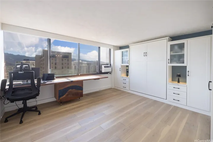 second bedroom with customized murphy bed pull out and matching quartz counter, built in cabinet,  Blackout curtains as well as sun solar shades, ocean blue epoxy inlay wood desk, hardwood flooring, AC unit