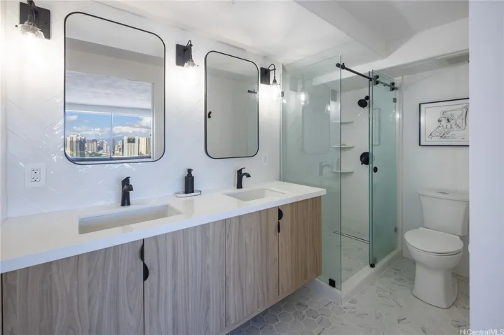 Primary bathroom renovated to include double sink, carrara hexagon tiled flooring and beautifully tiled chevron walls to create a sleek and modern designed bath experience.