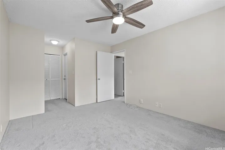 Primary bedroom facing closet and door to bathroom