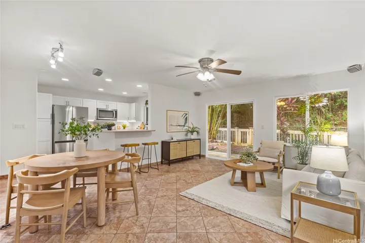 Warm afternoon sun shines through the windows with backyard views, stainless steel appliances and tile flooring.