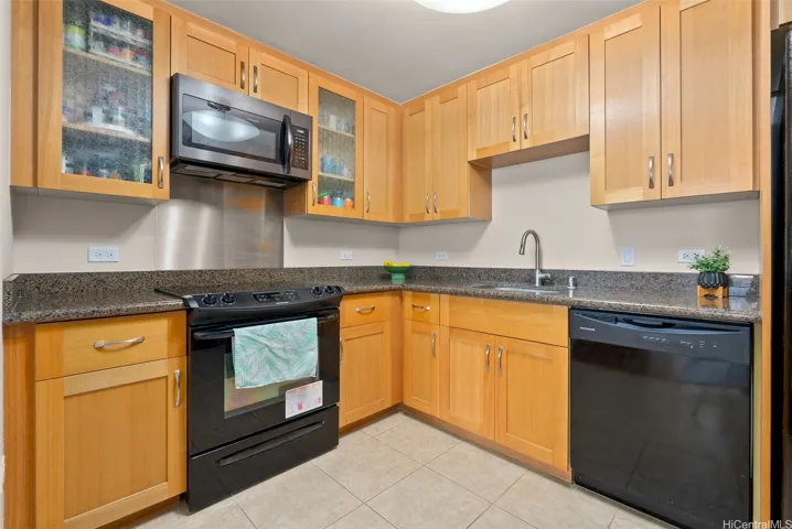 Well-maintained kitchen featuring durable ceramic tile flooring and a functional, open layout that flows seamlessly into the living area.