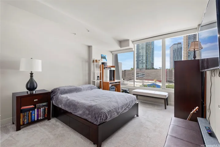 Bright second bedroom filled with natural light, offering flexible use as a guest room or home office.