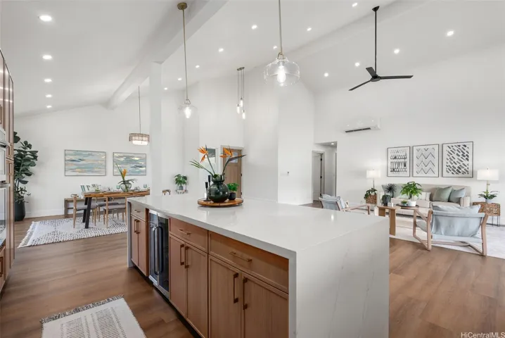 Oversized waterfall island anchors the modern kitchen, offering abundant space for gathering while overlooking the living and dining areas.
