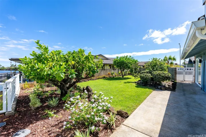 Beautifully landscaped side yard with lush lawn and waterfront access.

