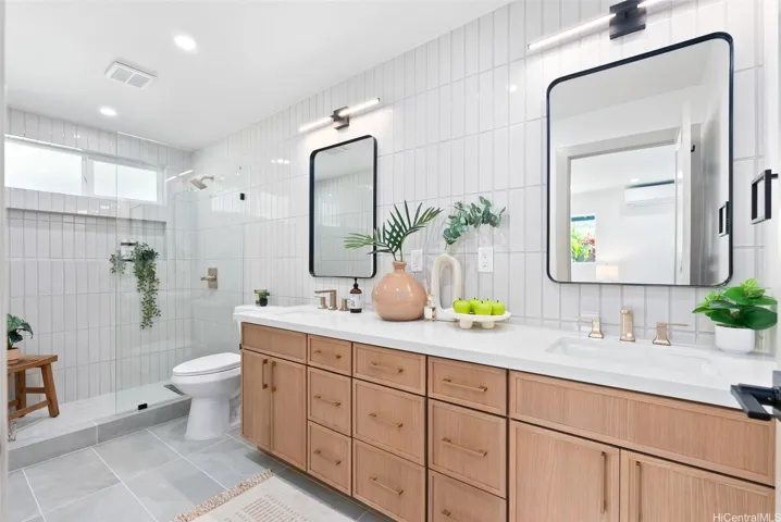 Beautifully finished primary bath with dual sinks and a spacious walk-in shower.
