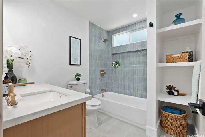 Beautifully updated guest bath with a tiled shower and built-in shelving.
