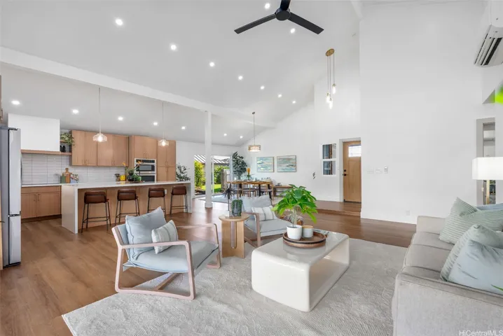 Wide-angle perspective of the living, dining, and kitchen areas.