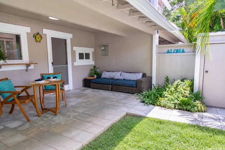 This generous covered lanai offers plenty of space to unwind or entertain, with a grassy area just beyond. | Enhanced