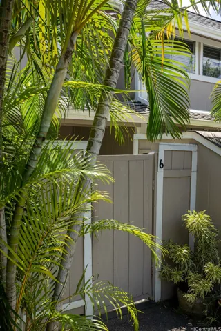 A private gated entry surrounded by lush tropical landscaping creates a welcoming arrival to the home. | Enhanced