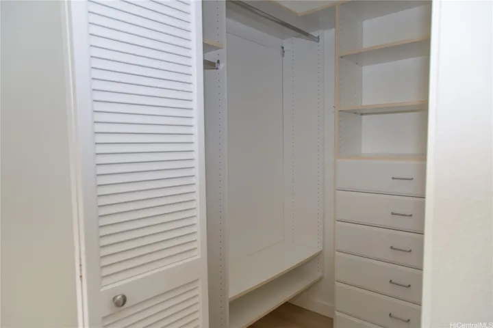 The walk-in closet is thoughtfully outfitted with built-in shelving, drawers and hanging space for excellent storage. | Enhanced