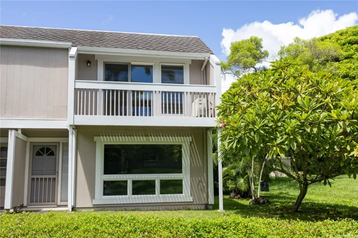 Rear view of this end unit, highlighting the oversized windows, private upper-level lanai and open greenspace just beyond the home. | Enhanced