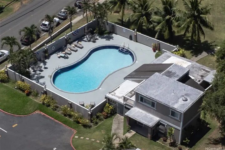 Enjoy the community pool and clubhouse area, featuring lounge chairs around the pool and picnic tables beneath the large covered clubhouse overhang, plus a refrigerator, sink and grill for easy poolside gatherings and relaxing afternoons.