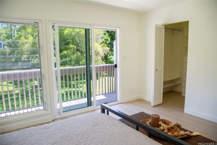 The primary bedroom opens through sliding glass doors to a private lanai overlooking the lush greenspace, bringing in beautiful natural light and a relaxing indoor-outdoor feel. | Enhanced