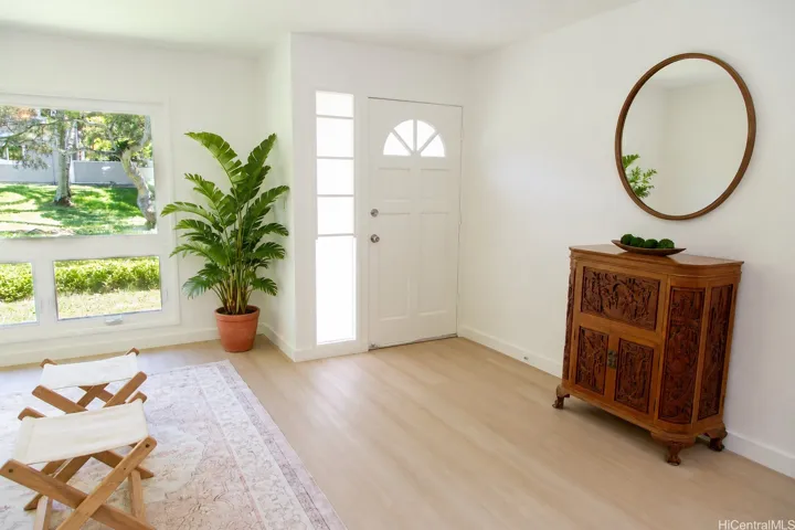 Natural light fills the living room, where the back door opens directly to the large greenspace behind, creating an airy and inviting connection to the outdoors.
