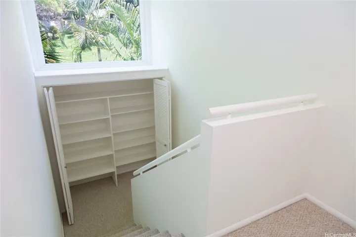 A huge picture window along the end-unit side floods the stairwell with natural light, while built-in storage beneath the window adds valuable extra space.