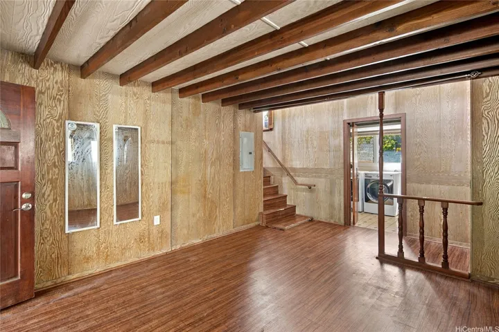 Lower bonus room with laundry room in the background and stairs up to the kitchen area.
