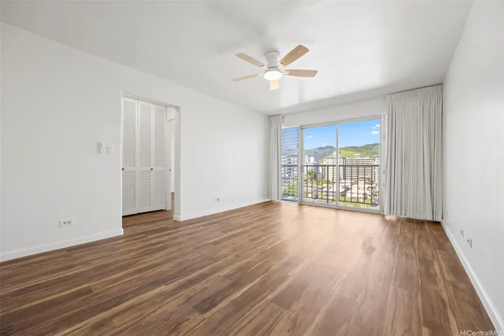 An open living room with views of Manoa Valley and Honolulu city lights.  Luxury vinyl flooring runs through out.