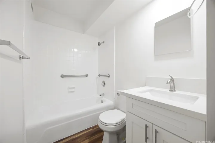 Full bath with a new vanity, refinished tub and surrounds, and luxury vinyl flooring through out.