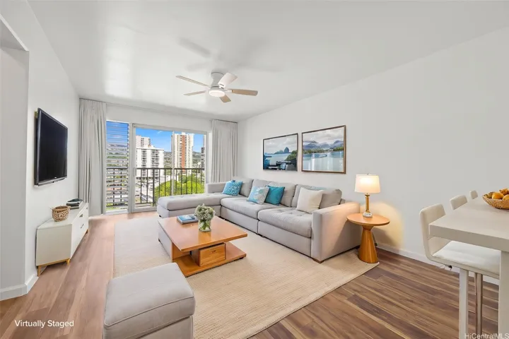 A virtually staged living room with views of Manoa Valley and Honolulu city lights
