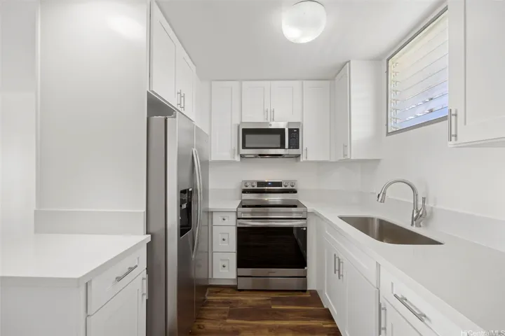 An updated kitchen with hardwood cabinetry, quartz counter tops and stainless steel appliances.  Luxury vinyl flooring runs through out.