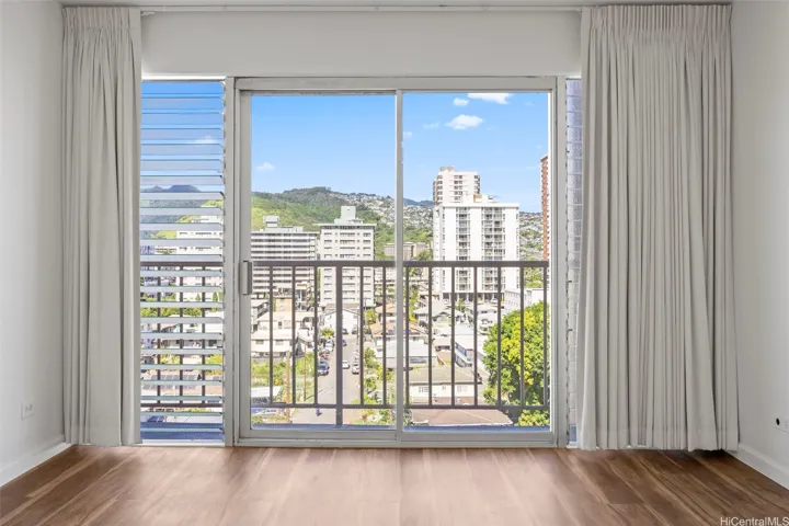 An open living room with views of Manoa Valley and Honolulu city lights.  Luxury vinyl flooring runs through out.