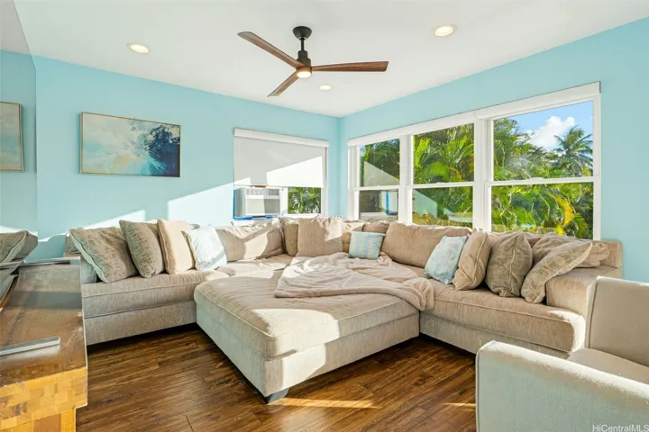 Bright upstairs living area with lush greenery and abundant natural light.