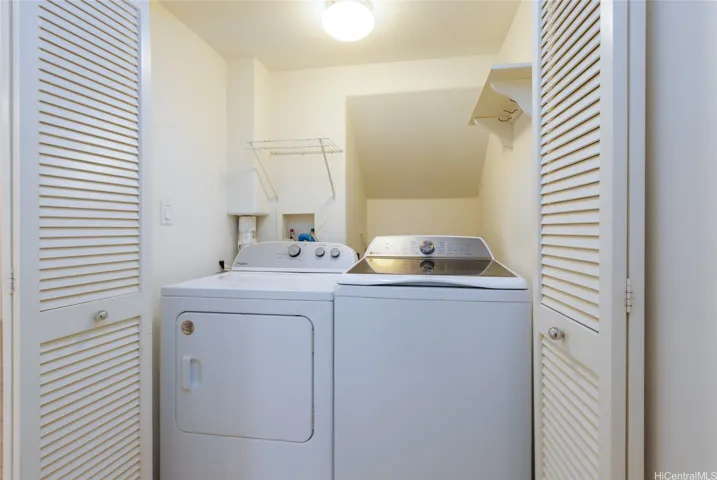 Full size washer and dryer across half bath.
