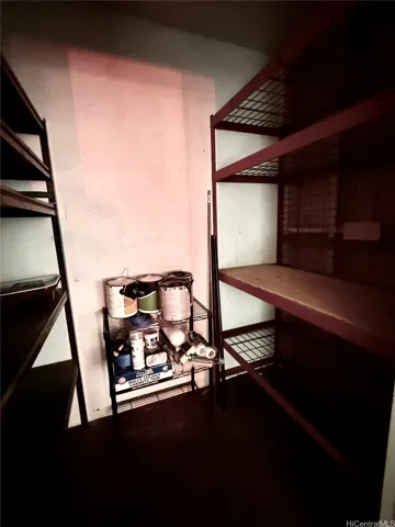 Storage unit with shelving behind parking stall