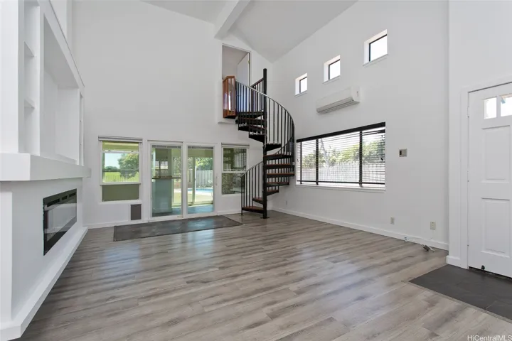 Living room with spiral stair case to bonus room
